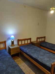 a room with three beds and a lamp on a table at Casa departamento Los Nietos in Puerto Quequén +31 photos