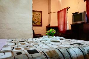 a room with a bed with flowers on it at Hostería Cabañas del Pescador in Cuenca