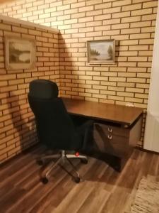 a desk and a chair in a room with a brick wall at Köpsintie 4 B in Pyhäsalmi