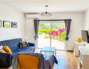 a living room with a blue couch and a sliding glass door at Prima Casa 005 in Paphos City