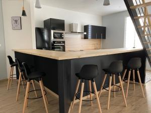 una cocina con barra con taburetes negros en Family Villa 29, en Le Tréport