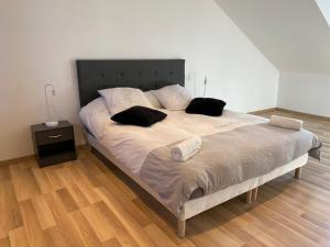 ein Bett mit zwei Kissen darauf in einem Schlafzimmer in der Unterkunft Family Villa 29 in Le Tréport