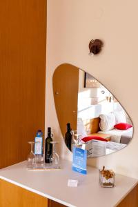 a mirror on a counter with bottles on it at Avra Hotel in Ormos Panagias