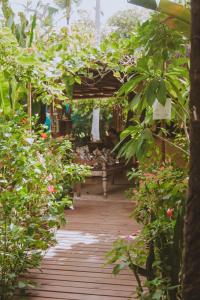 einen hölzernen Gehweg durch einen Garten mit Pflanzen in der Unterkunft Pousada Nativa in Caraíva