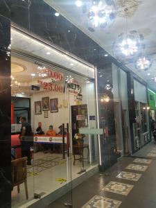 uma loja com uma janela de vidro com pessoas num quarto em Ghazrins Hotel Dataran Larkin em Johor Bahru