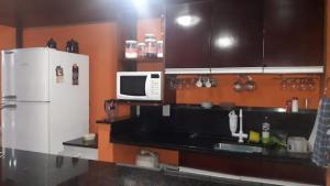 a kitchen with a white refrigerator and a microwave at ALDEIA DAS ÁGUAS PARK RESORT in Barra do Piraí +2 photos