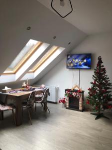 - un salon avec un arbre de Noël et une télévision dans l'établissement Apartament Andy Busteni 30 m de partie, à Buşteni