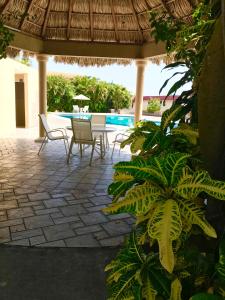 a patio with chairs and a table and a pool at Hotel Villas Dali Veracruz in Veracruz