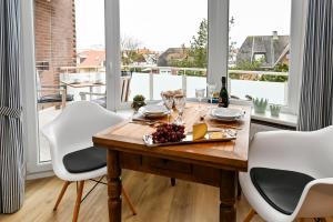 a dining room with a table and white chairs at Kamperhof 51 in Westerland (Sylt)