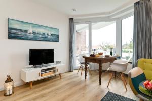 a living room with a television and a table with chairs at Kamperhof 51 in Westerland (Sylt)