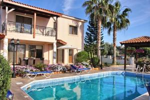 a house with a swimming pool in front of a house at Villa Paradise in Paphos