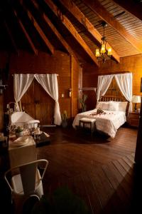 een slaapkamer met een bed in een kamer met houten vloeren bij Hacienda el Jibarito in San Sebastian