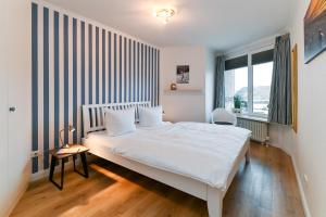 a bedroom with a white bed and a window at Kamperhof 51 in Westerland (Sylt)