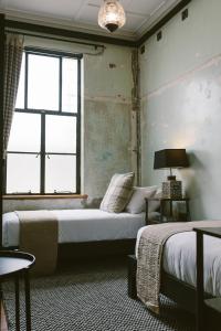 a bedroom with two beds and a window at The Convent Hotel in Auckland