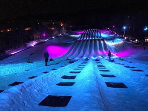 a snow covered ski slope at night with people on it at Mountainside Villas at Massanutten by TripForth in McGaheysville