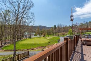 uma vista para um campo de golfe a partir de um deque de madeira em Mountainside Villas at Massanutten by TripForth em McGaheysville