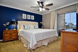 a bedroom with a bed and a ceiling fan at Direct Beachfront Delight in Siesta Key