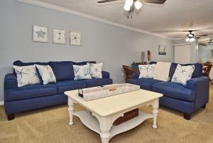 a living room with two blue couches and a coffee table at Direct Beachfront Delight in Siesta Key