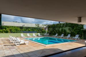 une piscine avec des chaises longues et une piscine dans l'établissement VOA Hotel União, à Caxambu