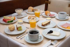 a table topped with plates of food and cups of coffee at VOA Hotel União in Caxambu