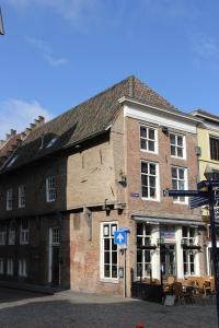 
a brick building with a clock on the front of it at Hotel 't Keershuys in Den Bosch
