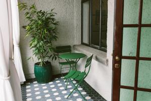 a table and chairs on a porch with a potted plant at The Convent Hotel in Auckland