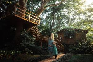 une femme qui tient un enfant en marche dans l'établissement Sweet Songs Jungle Lodge, à San Ignacio