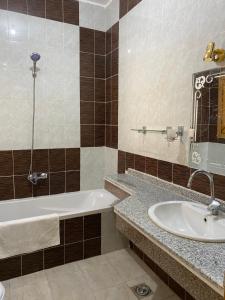 een badkamer met een bad en een wastafel bij Elsanosy Family Guest House - Luxor in Luxor