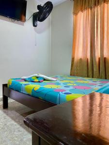 a bed with a colorful comforter in a room at Hotel Mansión Real in Bucaramanga