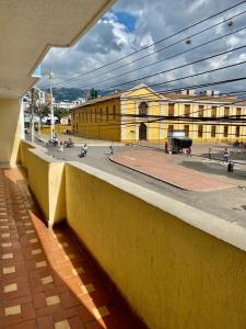 a building with a yellow wall next to a street at Hotel Mansión Real in Bucaramanga