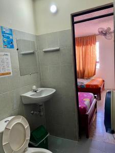 a bathroom with a toilet and a sink and a bed at Hotel Mansión Real in Bucaramanga