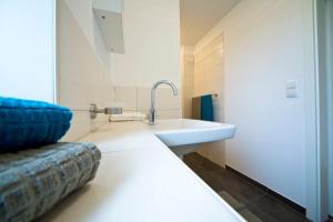 a bathroom with a sink and a couch at Q55 - Quartier 55 in Quickborn