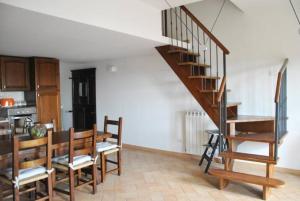 a living room with a staircase and a table and chairs at Civico 5 in Assisi