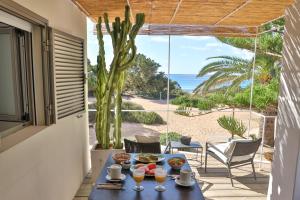 una mesa con comida y bebida en un balcón con vistas al océano en Talaya Formentera en Playa de Migjorn