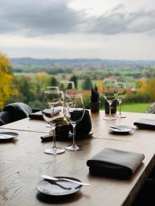 a wooden table with wine glasses and napkins at Vertes Feuilles in Saint-Sauveur