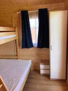 een slaapkamer met 2 stapelbedden en een raam bij WAKACYJNE ZAGAJE in Sarbinowo