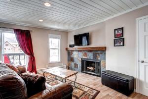 布雷肯里奇Panorama Alpine Condo: Hip Downtown Location的带沙发和壁炉的客厅