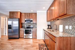 布雷肯里奇Panorama Alpine Condo: Hip Downtown Location的配有木质橱柜和不锈钢器具的厨房