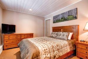 布雷肯里奇Panorama Alpine Condo: Hip Downtown Location的一间卧室，里面有一张床和一台平板电视 更多20张照片