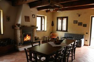 sala de estar con mesa y chimenea en Agriturismo Il Sentiero, en Montalto delle Marche