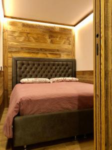 a bedroom with a bed with a wooden headboard at Central Apart Chalet in Breuil-Cervinia