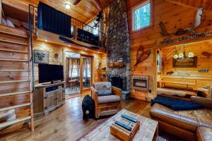 a living room with a fireplace in a log cabin at Cozy in the Woods in Madison
