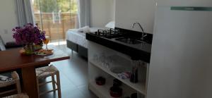 uma cozinha com um lavatório e um fogão em Pousada Suítes do Rosa na Praia do Rosa