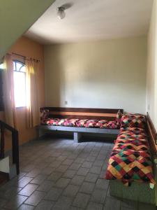 Una habitación con un sofá con una manta. en De Angelis - Casa de praia em Piuma com WI-FI en Piúma