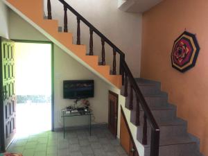 een woonkamer met een trap en een televisie bij De Angelis - Casa de praia em Piuma com WI-FI in Piúma