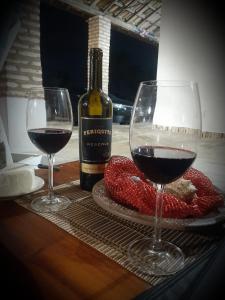POUSADA CHALÉ PARAÍSO - Icapui في إيكابوي: كأسين من النبيذ وزجاجة من النبيذ على طاولة