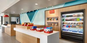 a store with a drink counter and a drink refrigerator at avid hotels - Detroit - Warren, an IHG Hotel in Warren