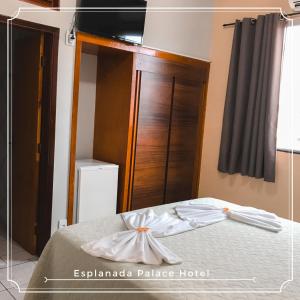 1 dormitorio con 1 cama y puerta de madera en Esplanada Palace Hotel, en Barra do Garças