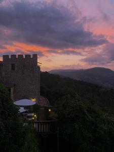 特里岡斯的住宿－特里岡斯城堡酒店，享有建筑美景,背景是日落