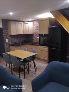 a kitchen with a table and chairs in a room at Les Glycines in Guewenheim